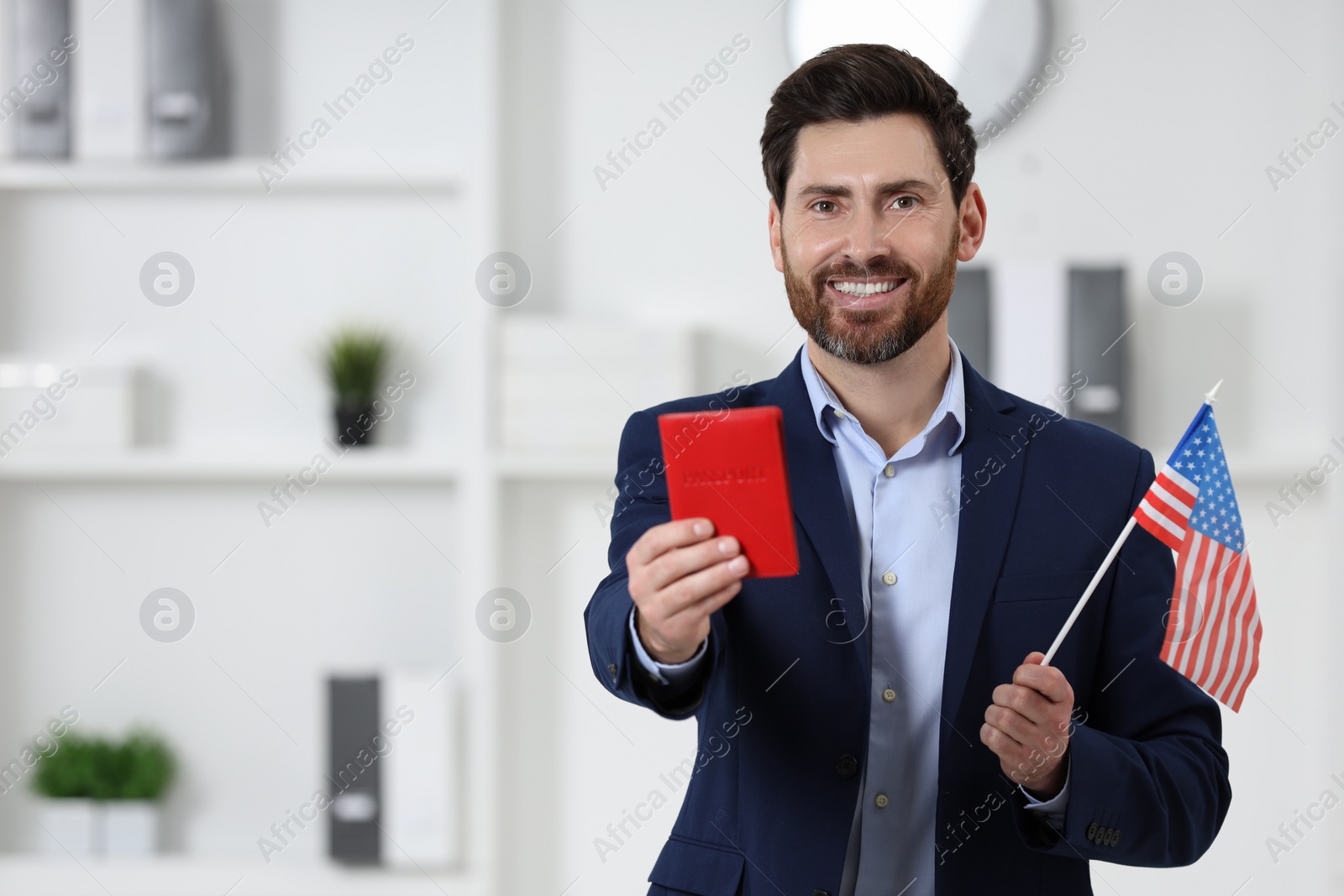 Photo of Immigration. Happy man with passport American flag indoors, space for text