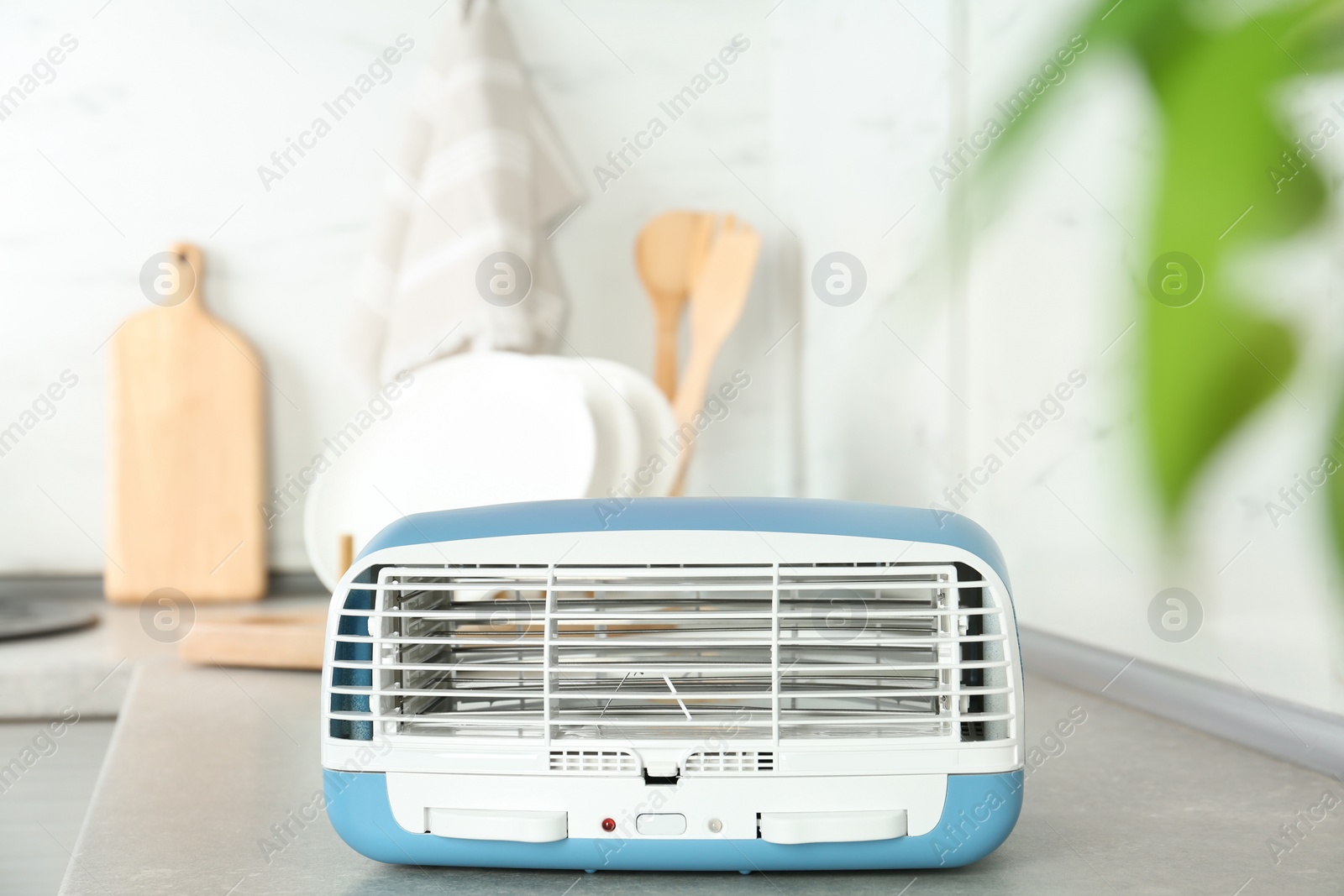 Photo of Stylish ionic air purifier in kitchen. Modern interior element