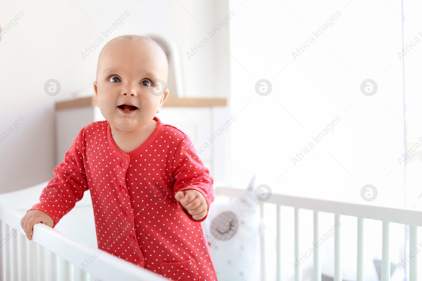 Photo of Cute baby girl in crib at home