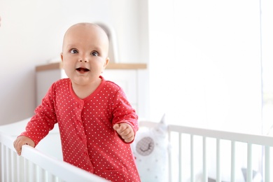 Cute baby girl in crib at home