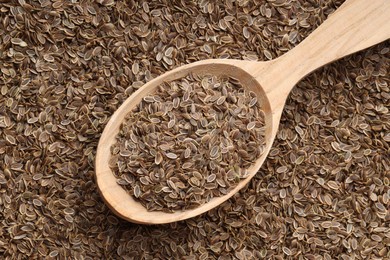 Photo of Dry dill seeds and wooden spoon, top view