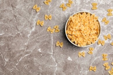 Bowl with raw pasta on table, top view