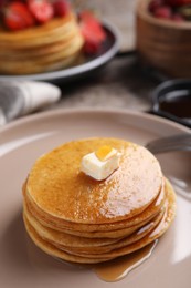 Tasty pancakes with butter and honey on plate, closeup