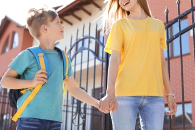 Young woman taking her child to school