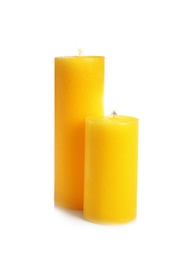 Photo of Two decorative yellow wax candles on white background