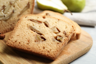 Photo of Tasty pear bread on wooden board, closeup. Homemade cake