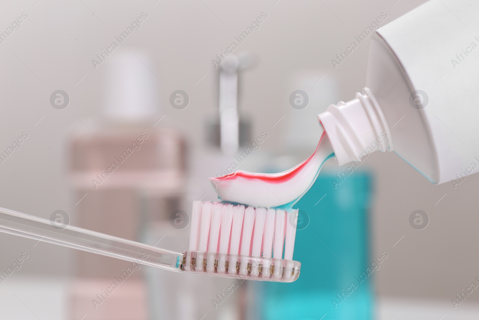 Photo of Applying paste on toothbrush near mouthwash, closeup