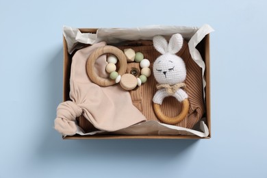 Photo of Different baby accessories in box on light blue background, top view