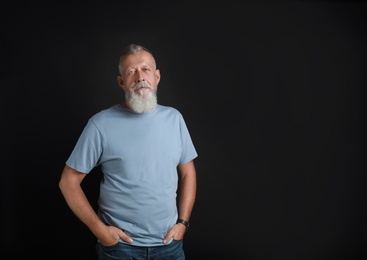 Portrait of handsome senior man on black background