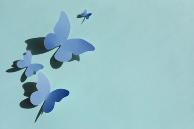 Image of Bright blue paper butterflies on cyan background