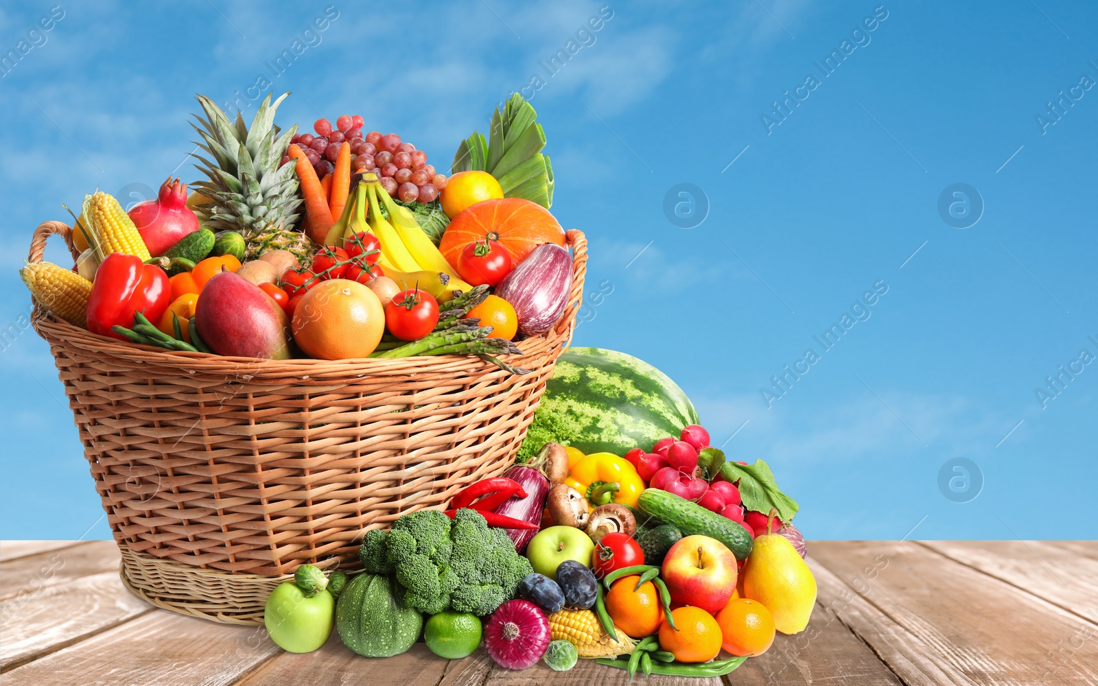 Image of Assortment of fresh organic fruits and vegetables on wooden table outdoors