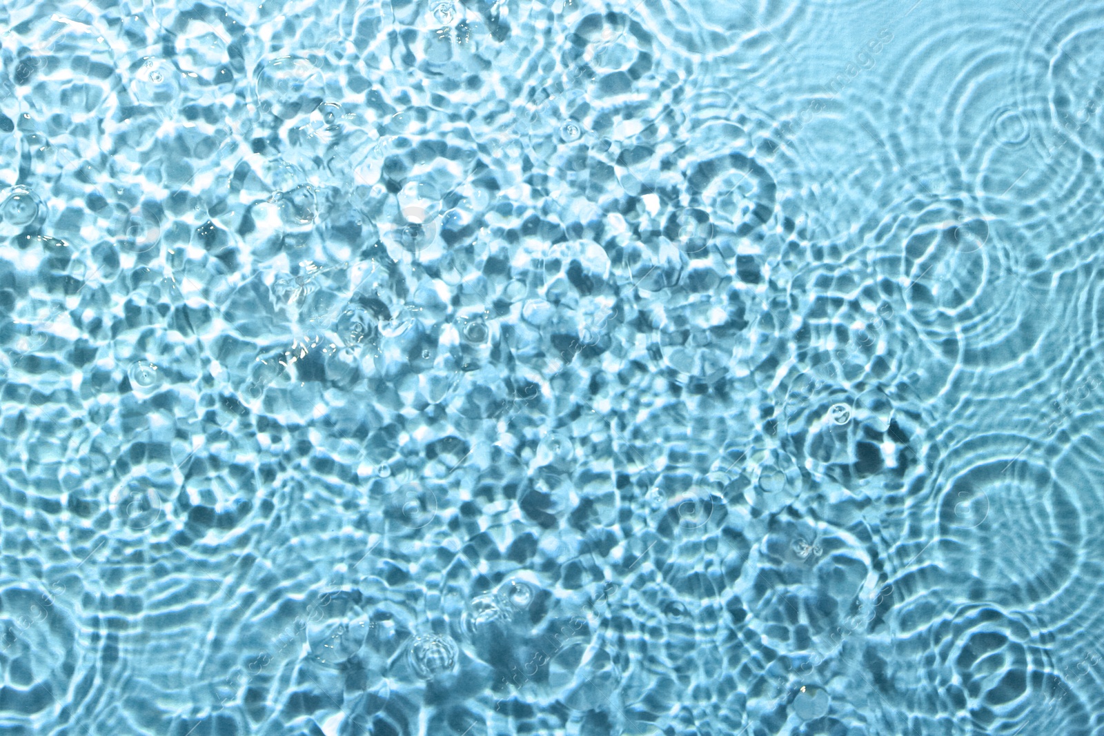 Image of Rippled surface of clear water on light blue background, top view