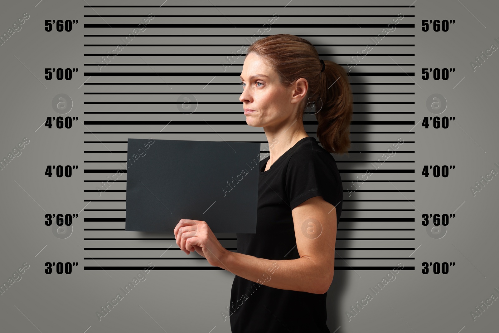 Image of Criminal mugshot. Arrested woman with blank card against height chart