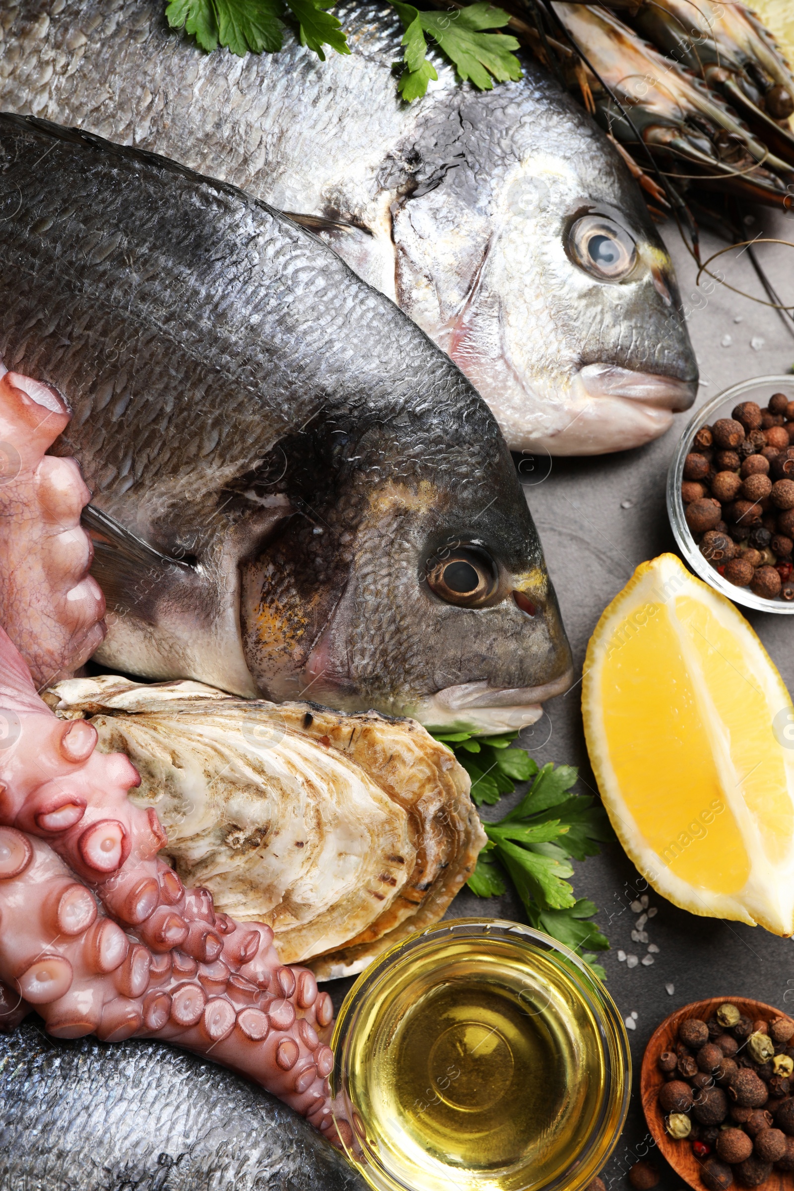 Photo of Flat lay composition with fresh raw dorado fish and different seafood on black table