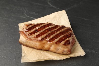 Photo of Delicious grilled beef steak on dark gray table