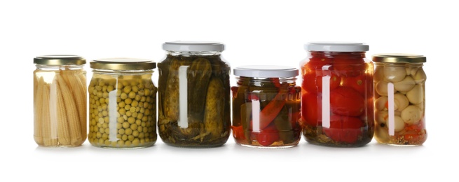 Photo of Glass jars with different pickled vegetables and mushrooms on white background