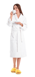 Photo of Young woman in bathrobe with cup of drink on white background