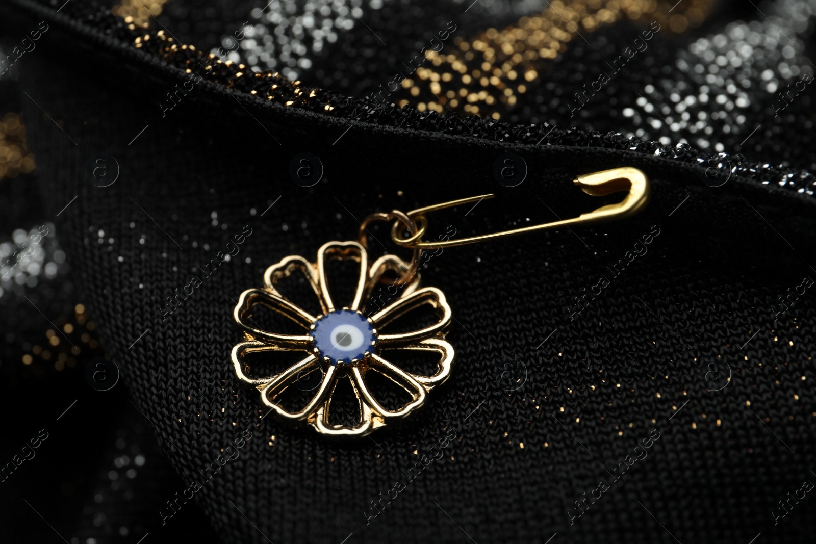 Photo of Evil eye safety pin on clothing, closeup