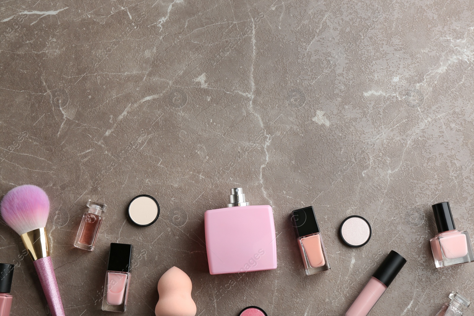 Photo of Flat lay composition with bottles of perfume and cosmetics on grey background. Space for text