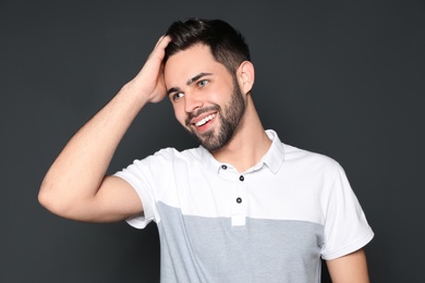 Photo of Portrait of handsome smiling man on grey background