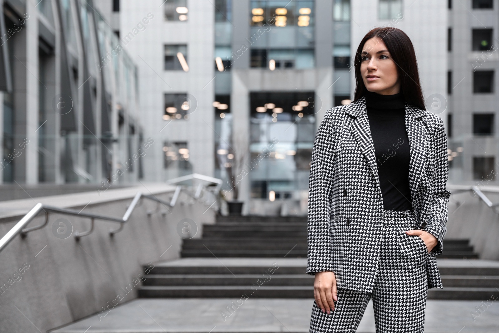 Photo of Portrait of beautiful woman in stylish suit on city street. Space for text