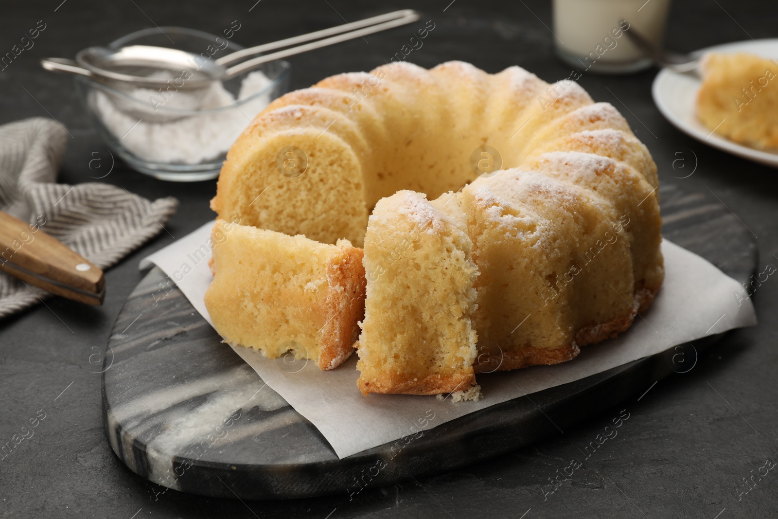 Photo of Delicious freshly baked sponge cake on black table