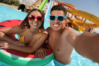 Photo of Happy couple taking selfie at water park. Summer vacation