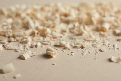 Curls of white chocolate on color background, closeup