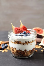 Photo of Tasty homemade granola dessert on dark grey table. Healthy breakfast