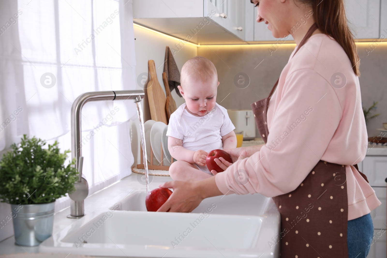 Photo of Mother and her cute little baby spending time together in kitchen