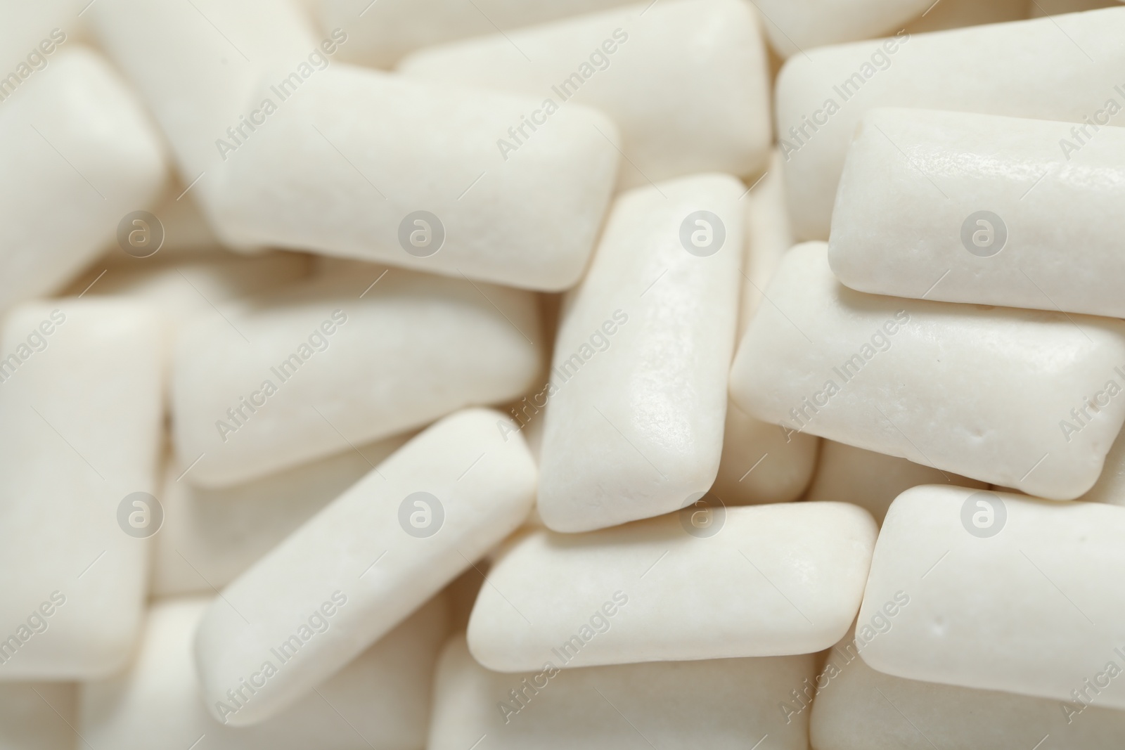 Photo of Tasty white chewing gums as background, closeup