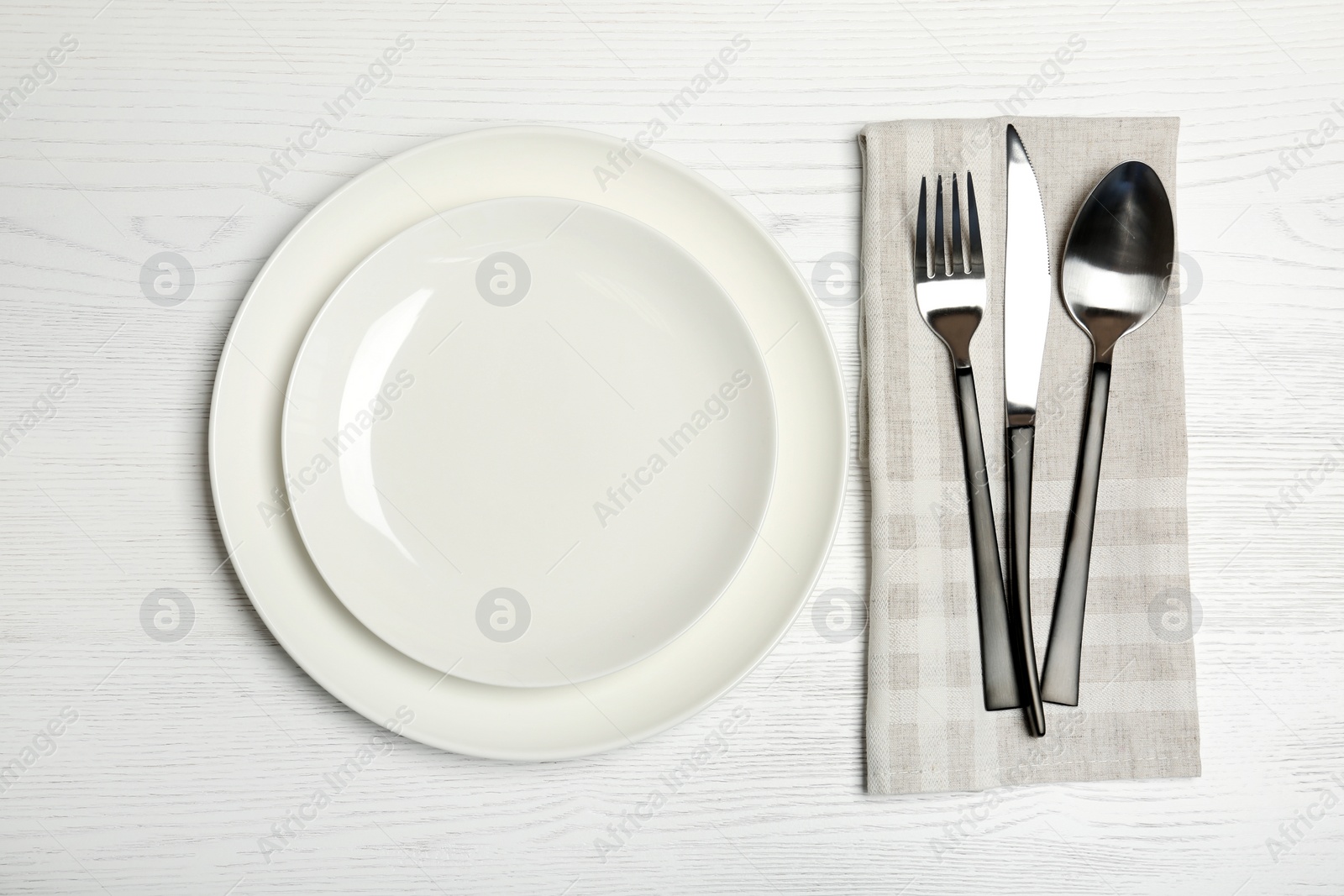 Photo of Plates and cutlery on wooden table, top view. New setting