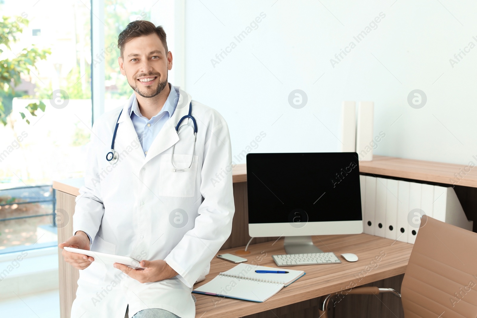 Photo of Male medical assistant near workplace in clinic. Health care service