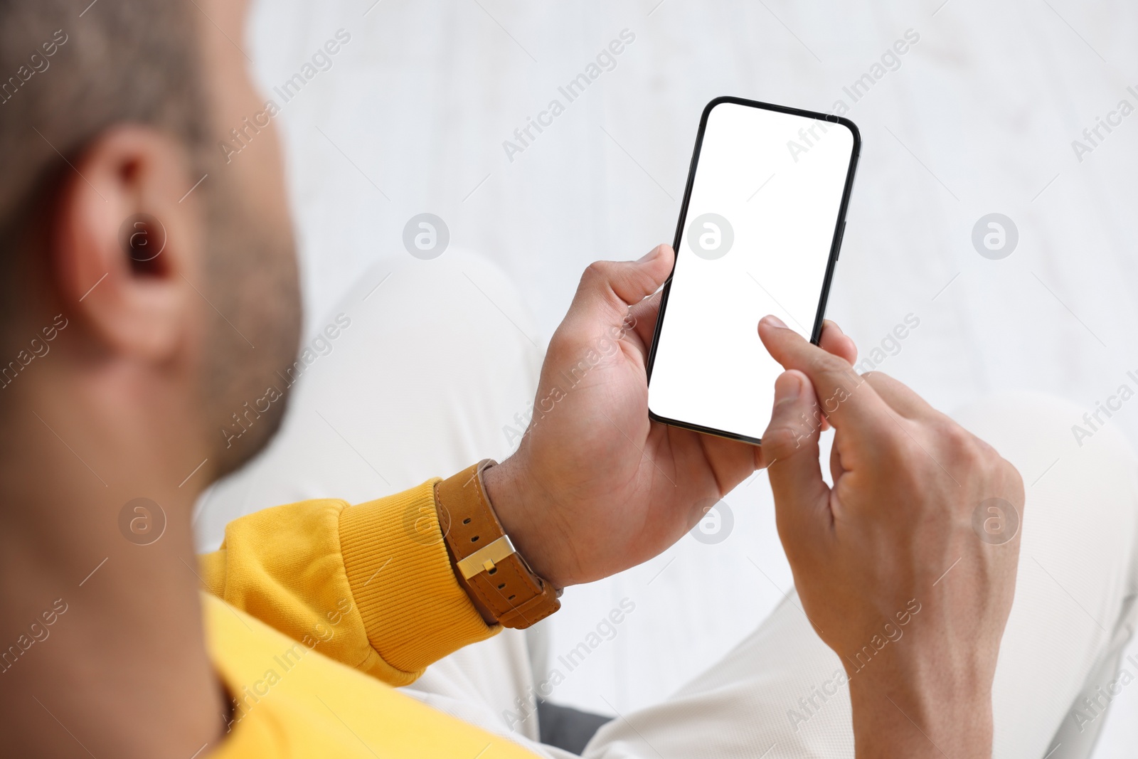 Photo of Man using modern mobile phone indoors, closeup