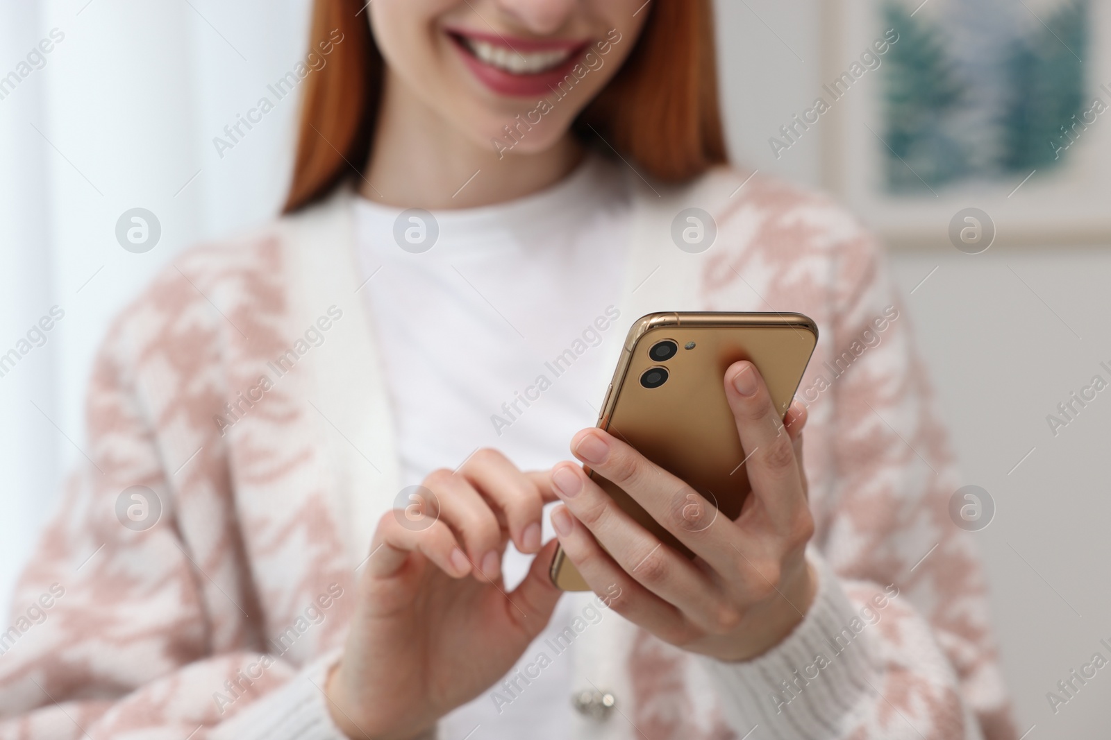 Photo of Woman sending message via smartphone indoors, closeup