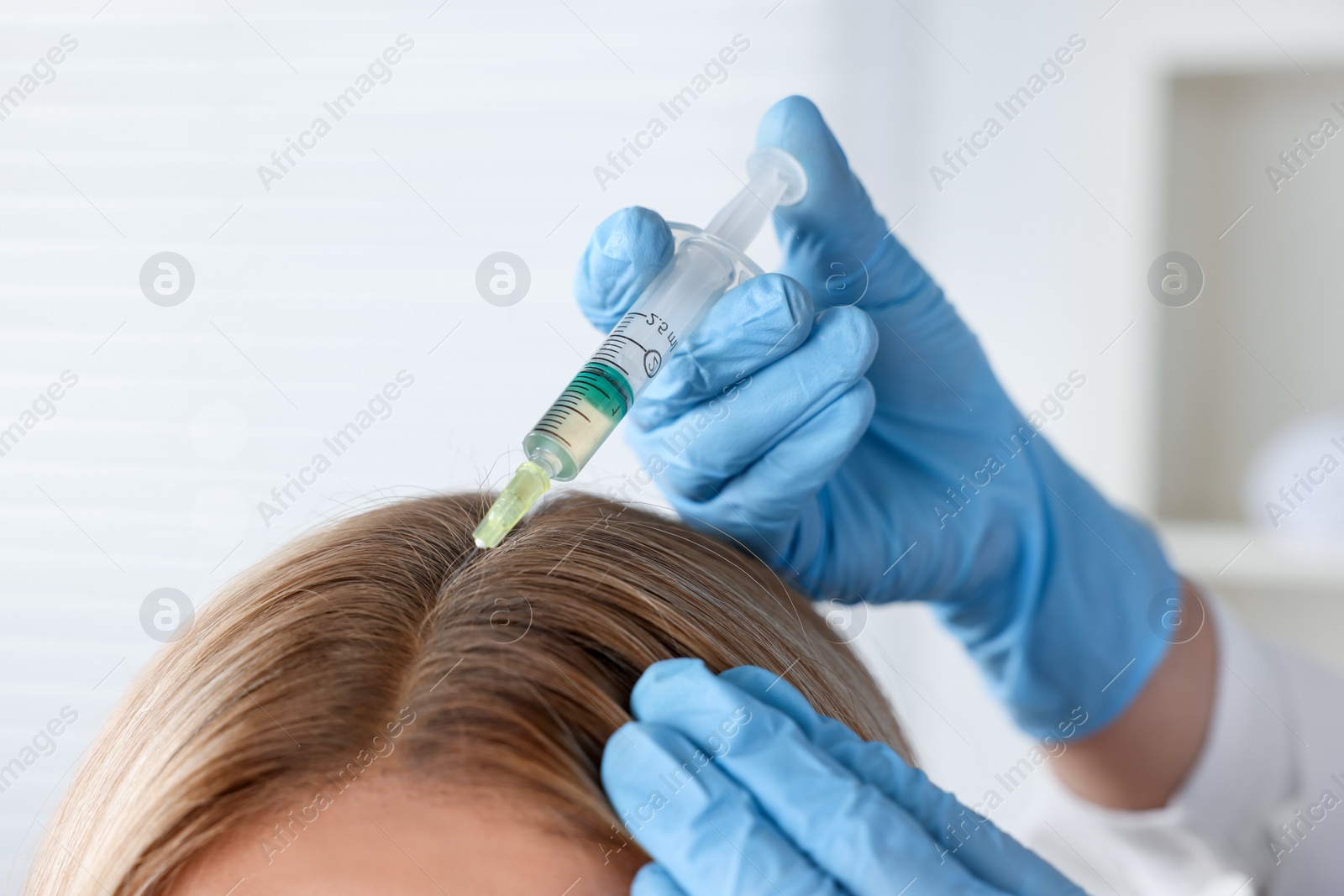 Photo of Trichologist giving injection to patient in clinic, closeup