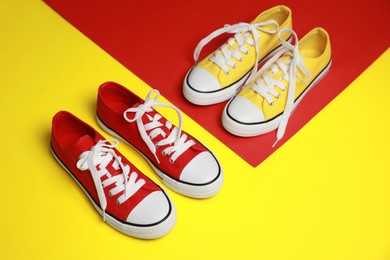 Red and yellow classic old school sneakers on color background