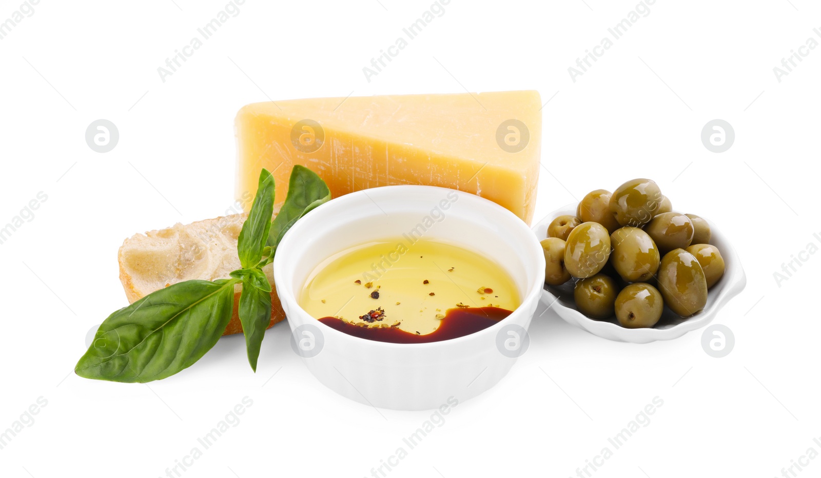 Photo of Bowl of organic balsamic vinegar with oil, basil, bread, cheese and olives isolated on white