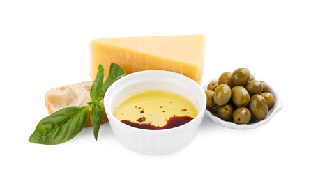 Photo of Bowl of organic balsamic vinegar with oil, basil, bread, cheese and olives isolated on white
