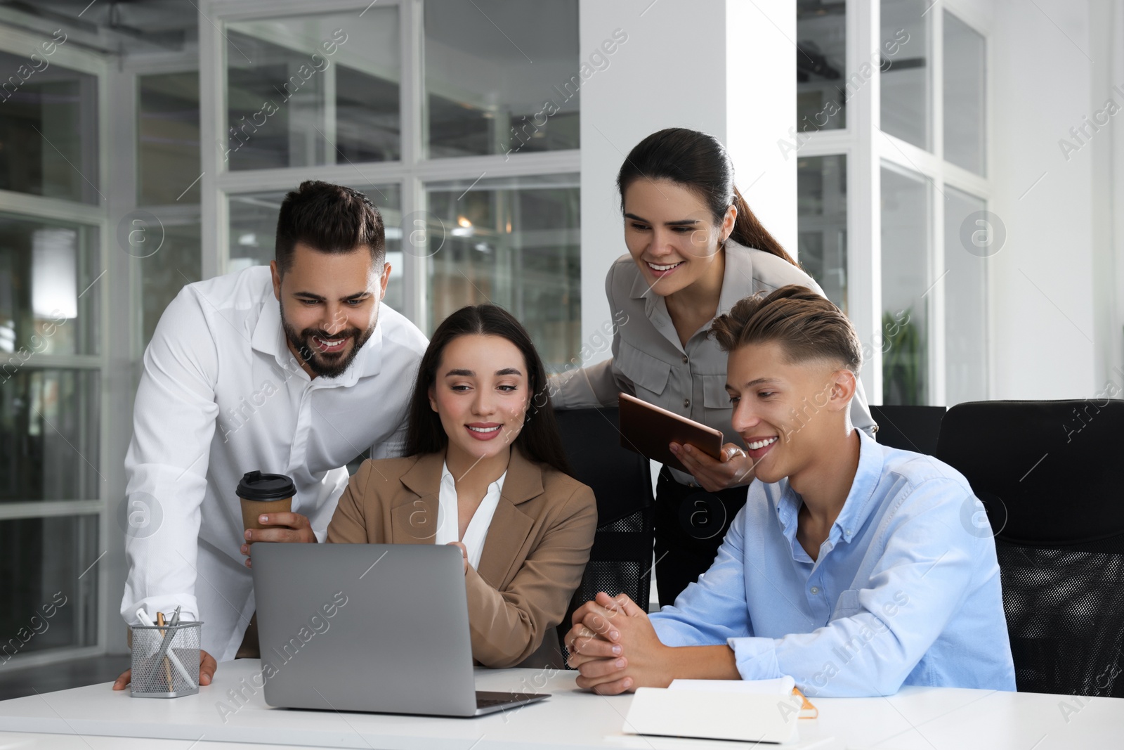 Photo of Colleagues working together in open plan office