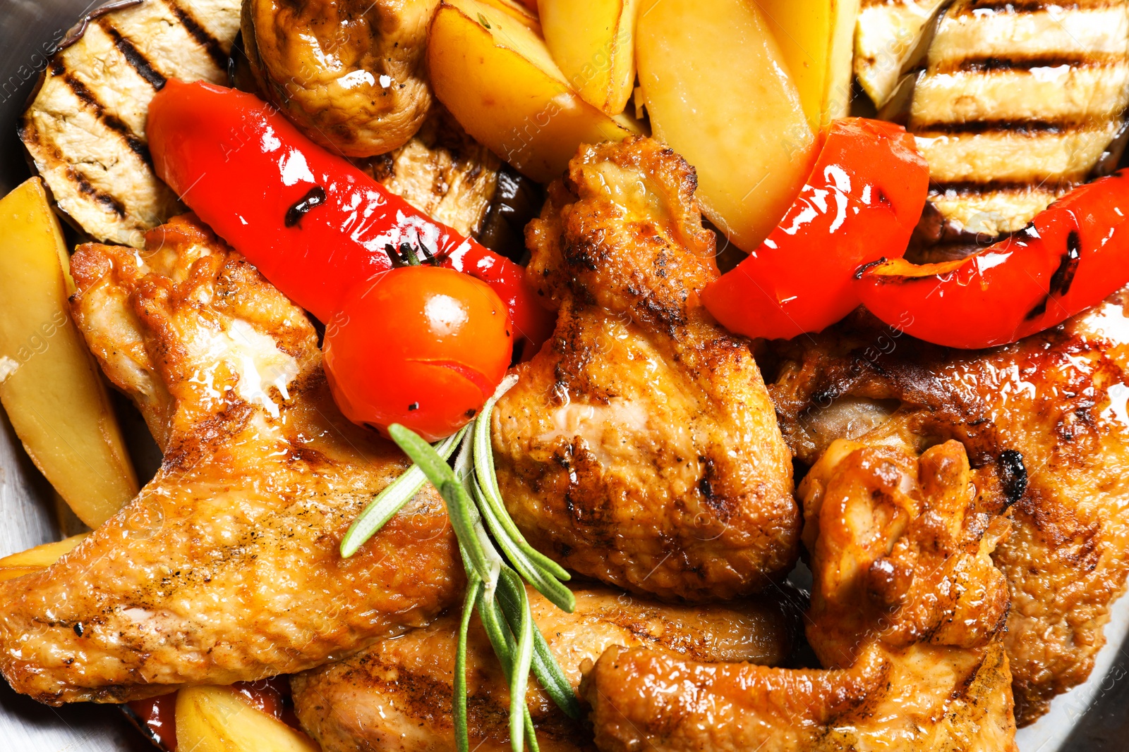 Photo of Delicious barbecued chicken wings with garnish served in wok, closeup