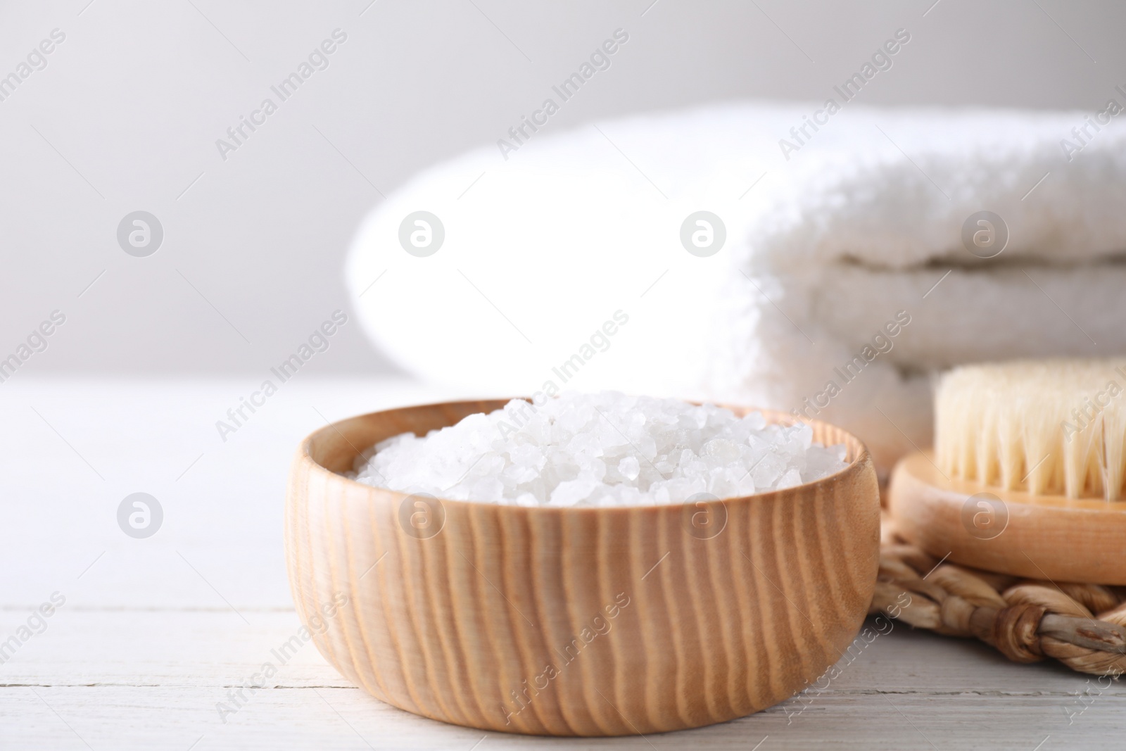 Photo of White sea salt for spa scrubbing procedure on wooden table