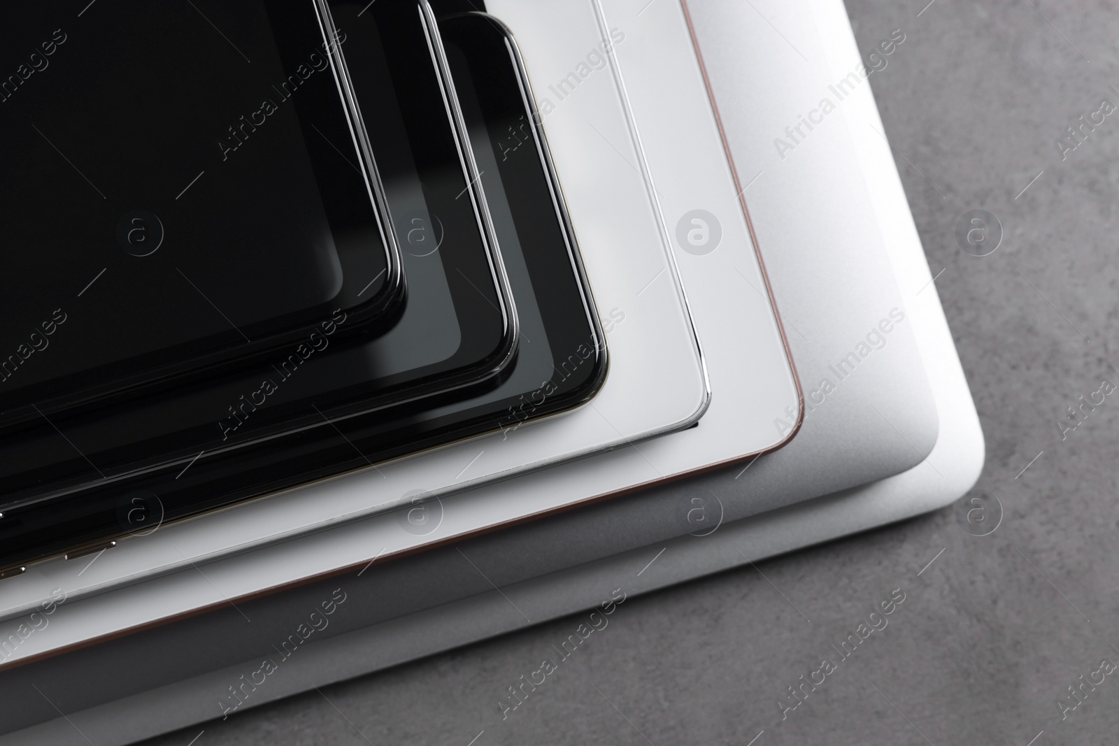 Photo of Many different modern gadgets on grey table, closeup