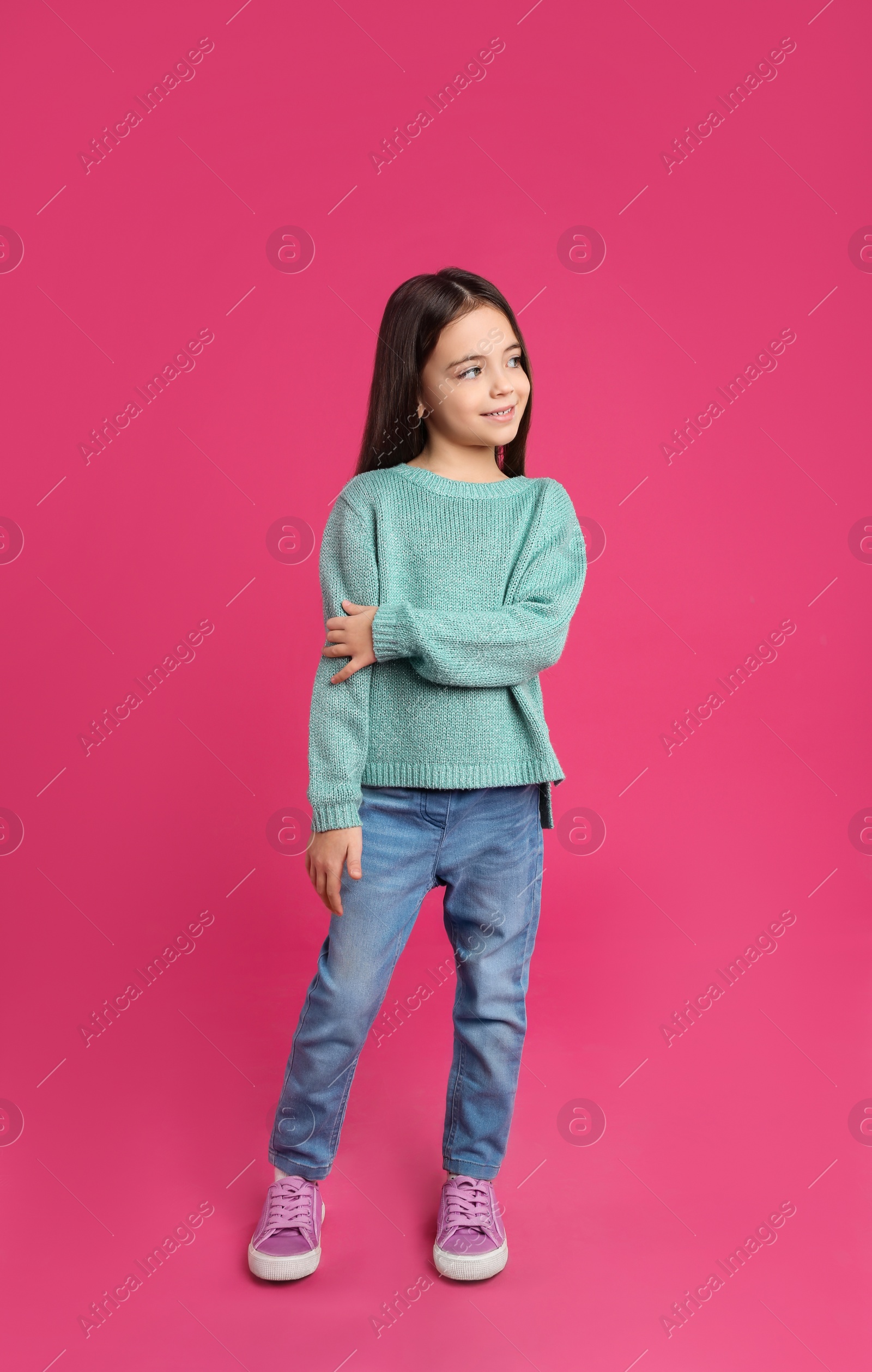 Photo of Cute little girl posing on pink background