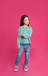 Cute little girl posing on pink background