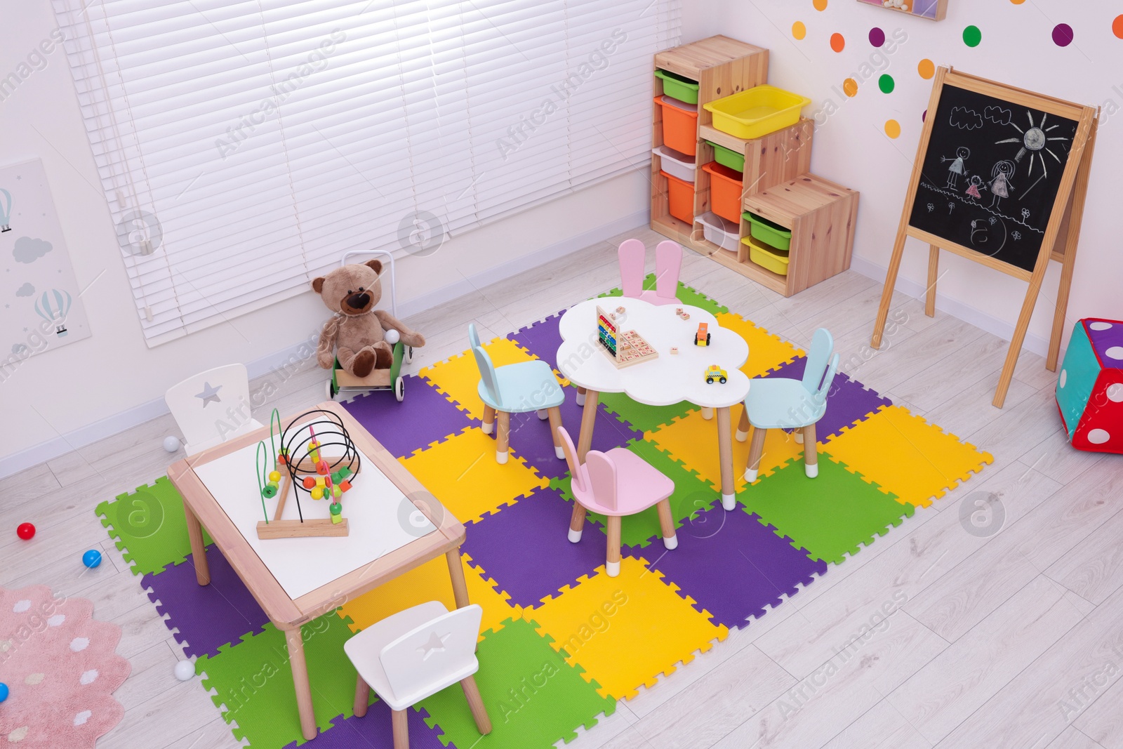 Photo of Stylish kindergarten interior with toys and modern furniture, above view