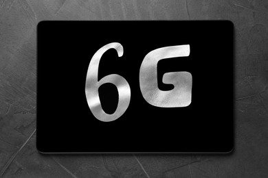 Photo of 6G technology, Internet concept. Number and letter with tablet on grey table, top view