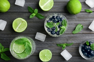 Flat lay composition with detox lemonade and ingredients on wooden background