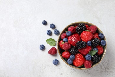 Different fresh ripe berries on light grey table, flat lay. Space for text