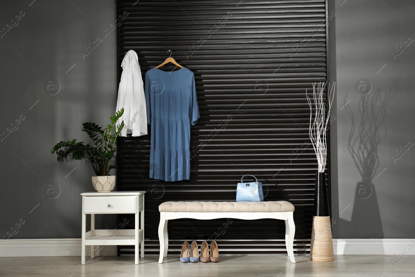 Photo of Hallway interior with bench, clothes and little cabinet